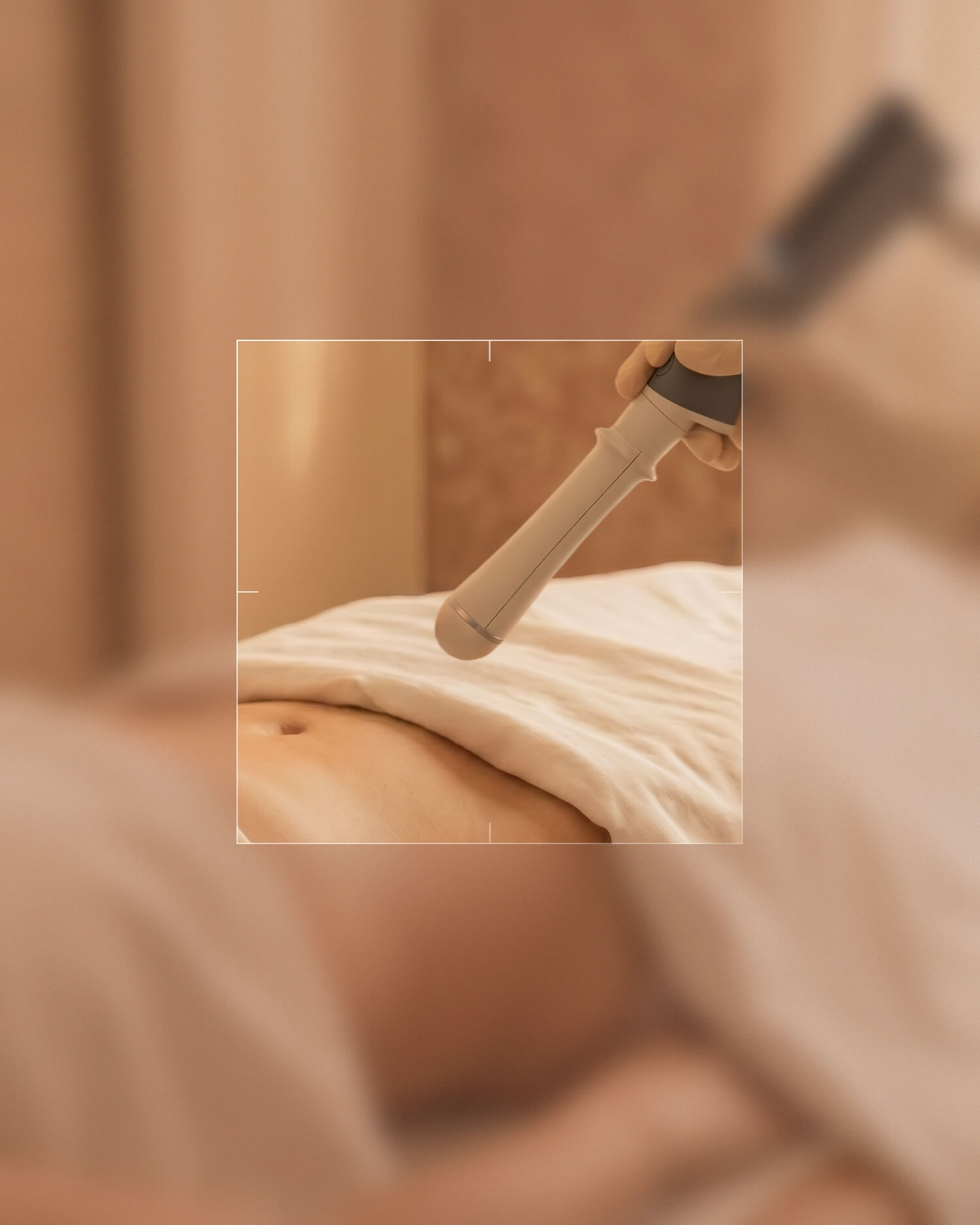 Hand mit Handschuh hält ein medizinisches Gerät über den Bauch einer liegenden Person